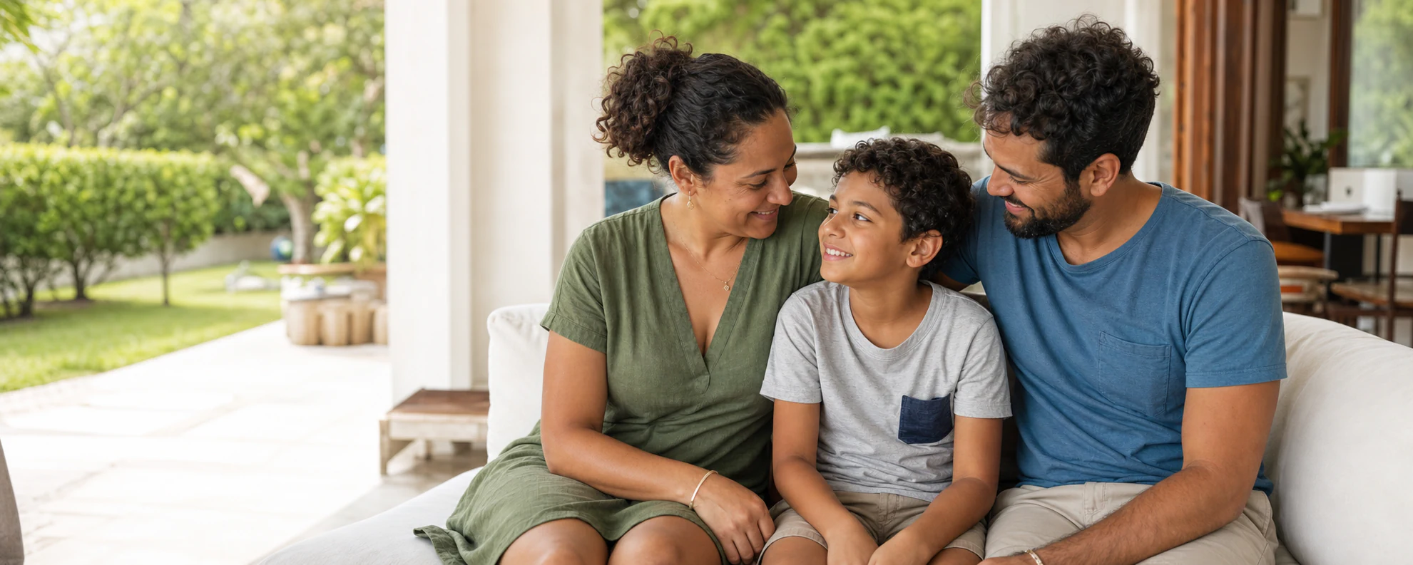 Família formada por mãe, pai e filho reunida em casa