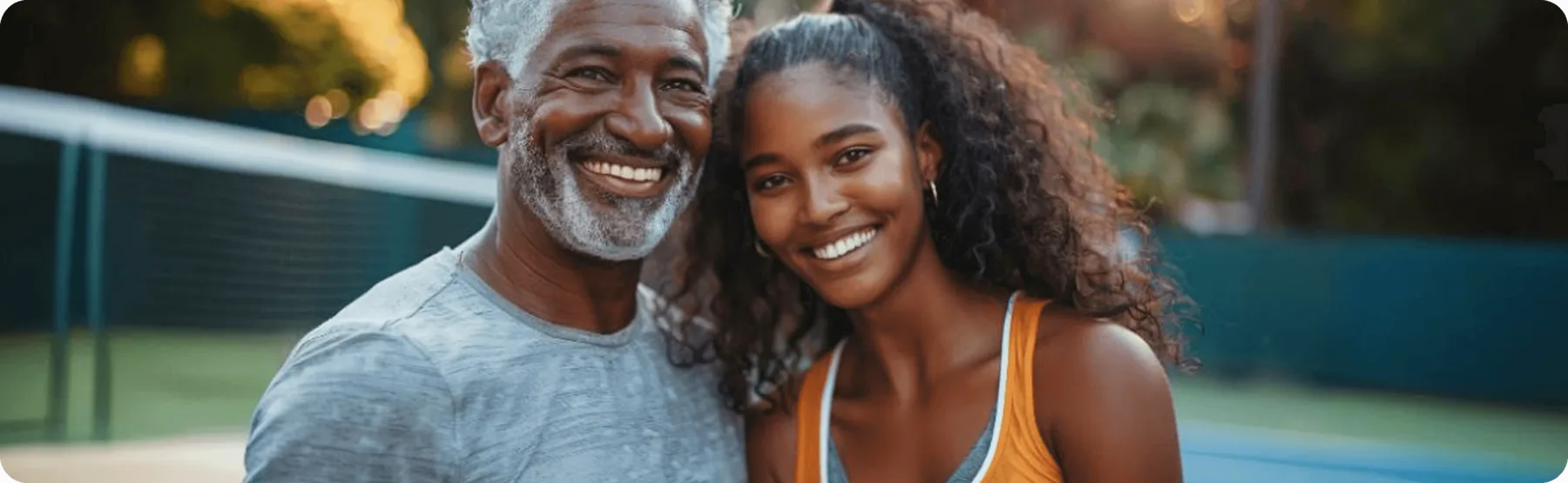Homem mais velho e mulher adulta sorriem juntos ao ar livre